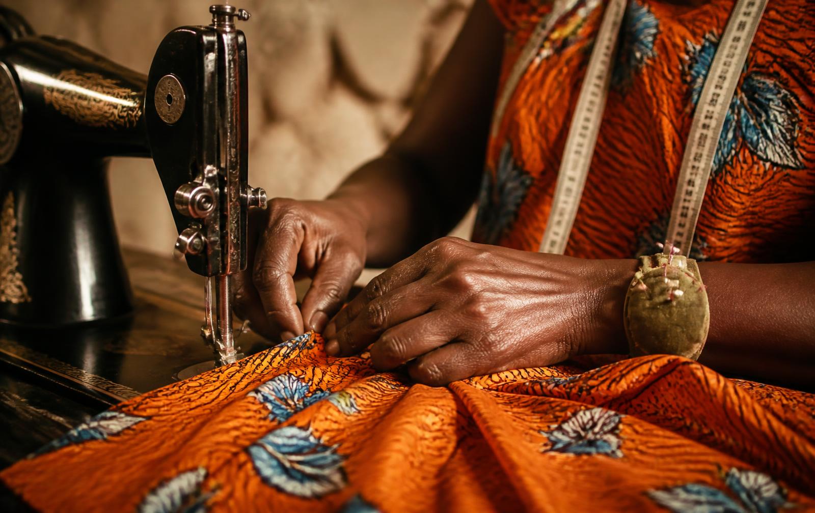 Couturière travaillant un tissu wax orange